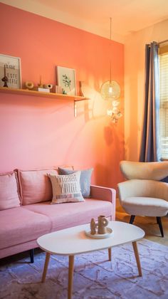 a living room filled with furniture and pink walls