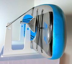 a blue and white clock hanging from the side of a wall