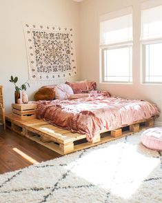 a bed made out of wooden pallets in a room with white rugs on the floor