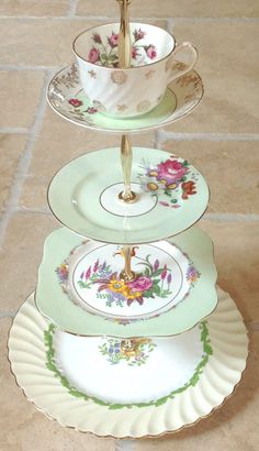 three plates stacked on top of each other with cups and saucers in the middle