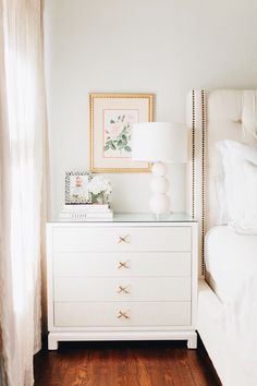 a bedroom with a bed, nightstand and pictures on the wall