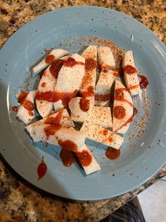 some food on a blue plate with sauce and seasoning sprinkled around it