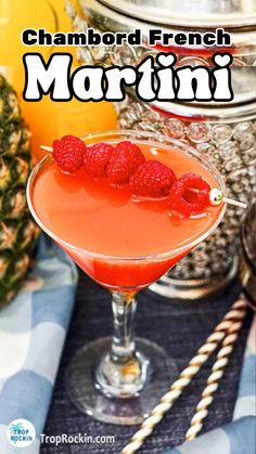 a close up of a drink in a glass with raspberries on the rim