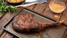 a piece of steak on a pan with parsley and seasoning next to it