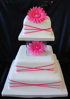 three tiered white cake with pink flowers on top