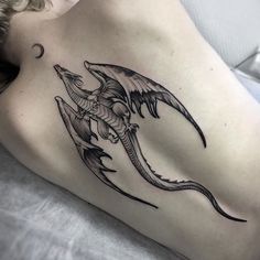 a woman's stomach with a dragon tattoo on it