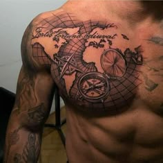 a man's chest with a map and compass tattoo on it