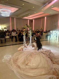 a dog sitting on top of a wedding dress in front of a group of people