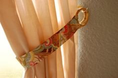 a tie hanging on the side of a window sill in front of a curtain