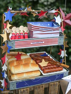 a patriotic dessert stand with hotdogs, pretzels and buns on it