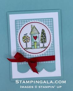 a handmade card with a red ribbon on the bottom and an image of a house