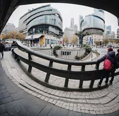 two people are standing on the edge of a bridge