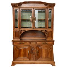 an antique wooden china cabinet with glass doors and carvings on the front, side panels