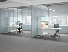 an empty office with glass walls and desks