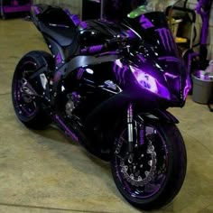 a purple and black motorcycle parked in a garage