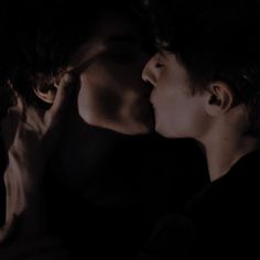 two people kissing each other in the dark