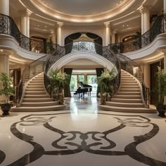 a grand piano in the middle of a large foyer with marble flooring and handrails