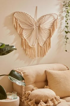 a living room with a white couch and some plants on the wall next to it