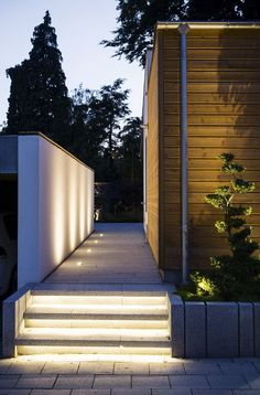 the stairs are lit up at night with light coming from them and trees in the background