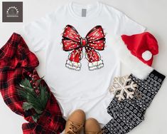 Christmas Coquette Bow Shirt, Christmas Santa Bow Shirt, Santa Claus Bow Shirt, Christmas Lights Shirt, Christmas Mom Gift Shirt, Xmas Holiday Shirt Welcome to MamaBearApparell! I am a professional designer and a Mama of twins. As a professional designer, I am delighted to offer you designed t-shirts that your entire family will love and cherish, making your special moments even more beautiful. We are working to provide you with high-quality soft t-shirts and sweatshirts with trendy designs. We prioritize quality materials and stunning designs to offer you the best service possible. Our handmade items will be the perfect choice for your celebrations, vacations, graduations, or birthday & wedding parties and holidays (such as Christmas, Thanksgiving ..)  Discount available on bulk orders! F Red Holiday Shirt For Gift, Red Holiday Shirt Gift, Holiday Red Shirt As Gift, White Festive Shirt For Christmas, White Festive Christmas Shirt, Red Christmas Shirt For Holiday, Holiday Gift Red T-shirt, Red Festive Holiday T-shirt, Festive Red Holiday T-shirt