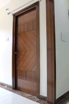 two wooden doors in the corner of a room with tile flooring and white walls