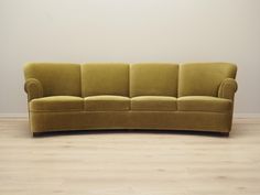 a green couch sitting on top of a hard wood floor