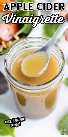 an apple cider vinaigrette in a jar with a spoon sticking out of it