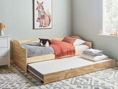 a dog laying on top of a bed in a room with gray walls and rugs