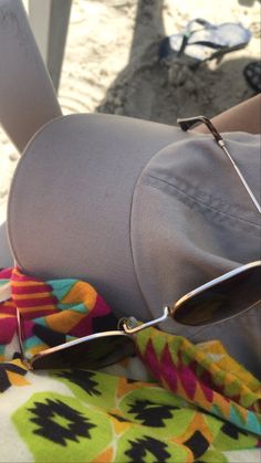 a person wearing sunglasses and sitting on the beach