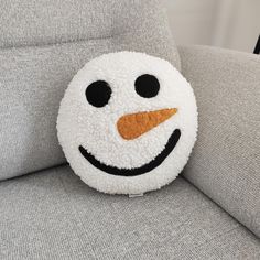 a close up of a snowman pillow on a couch