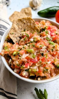 a white bowl filled with salsa and tortilla chips on top of a table