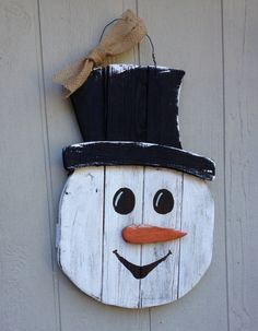 a wooden snowman hanging on the side of a building