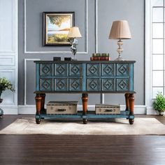 a living room with a blue dresser and lamp on the sideboard in front of it