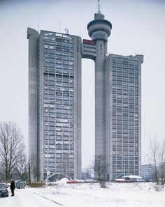 two tall buildings in the middle of a snow covered field