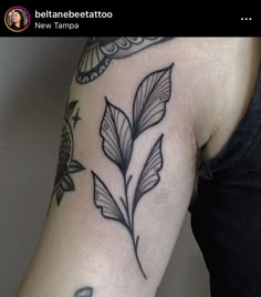 a black and white photo of a woman's arm with tattoos on it