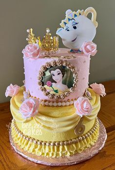 a pink and yellow cake with a princess on top