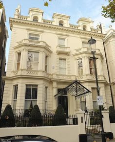 a large white building with lots of windows and balconies on the top floor