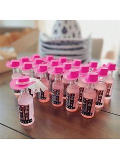 many bottles with pink caps are lined up on a table