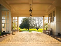 an open walkway leading to a house with large windows on each side and a bench at the end