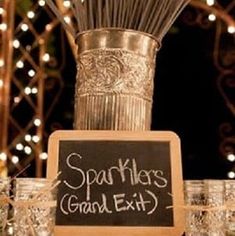 there is a sign that says sparklers grand exit next to some glasses and candles