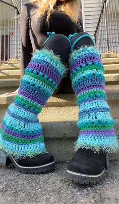 a woman is sitting on the steps with her legs up wearing crocheted socks