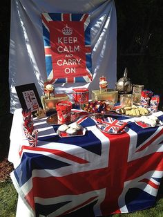 a british flag covered table with food on it and a sign that says keep calm