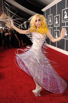 lady in white dress holding an umbrella on red carpet