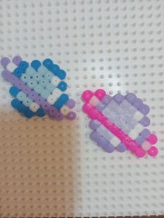 two pieces of plastic sitting on top of a white table next to each other with holes in them