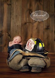 a baby is sleeping in a fireman's hat