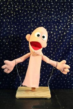 a puppet that is standing on a wooden board