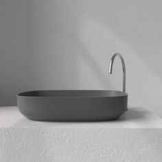 an oval sink sits on top of a white countertop in front of a wall