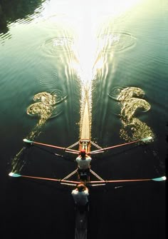 an airplane is flying over the water with its wings spread out and it's reflection in the water