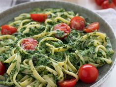 pasta with pesto and tomatoes in a bowl