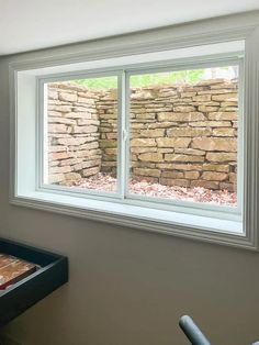 a room with a brick wall and two windows that have glass panes on them